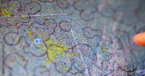 An extreme closeup shot of a pilot examining VFR maps of the North American east coast on a tablet PC before a flight.
