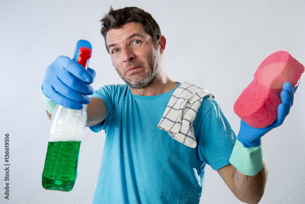 domestic service man or tired husband angry and stressed house cleaning with spray bottle and sponge domestic service man or tired husband angry and stressed house cleaning with spray bottle and sponge