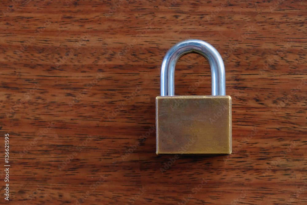 Fototapeta premium Padlock on the brown wooden table background.