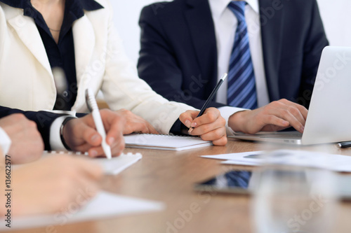 Group of business people at meeting, close up of human hands in work with pen and papers