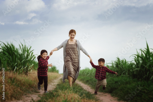 Image of Kids and mother running in the fields,them so happy joyful,Happy family concept