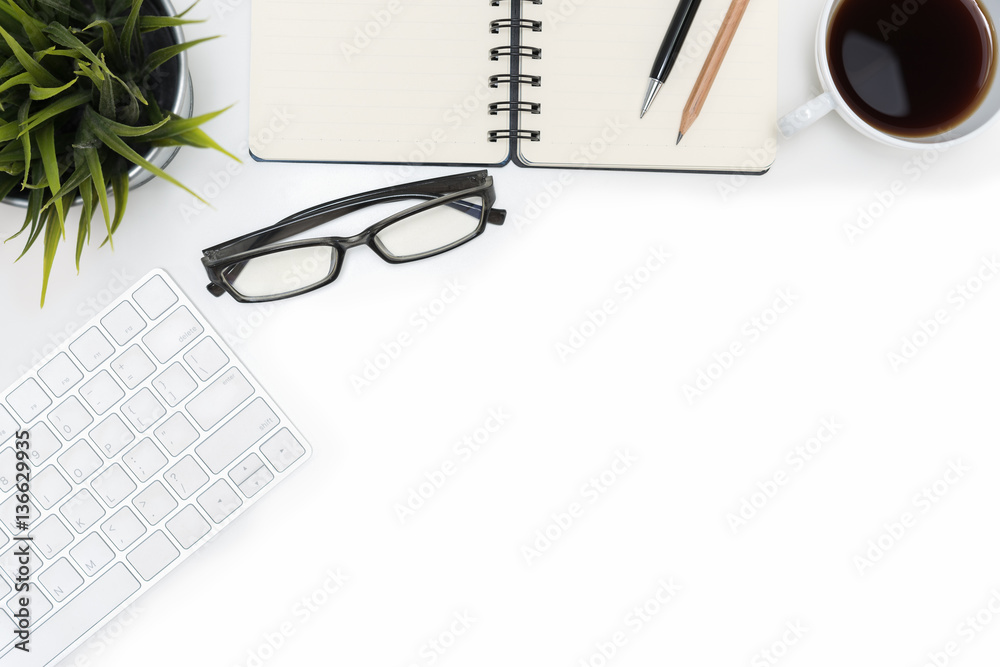 Open spiral blank notebook and computer on white desk