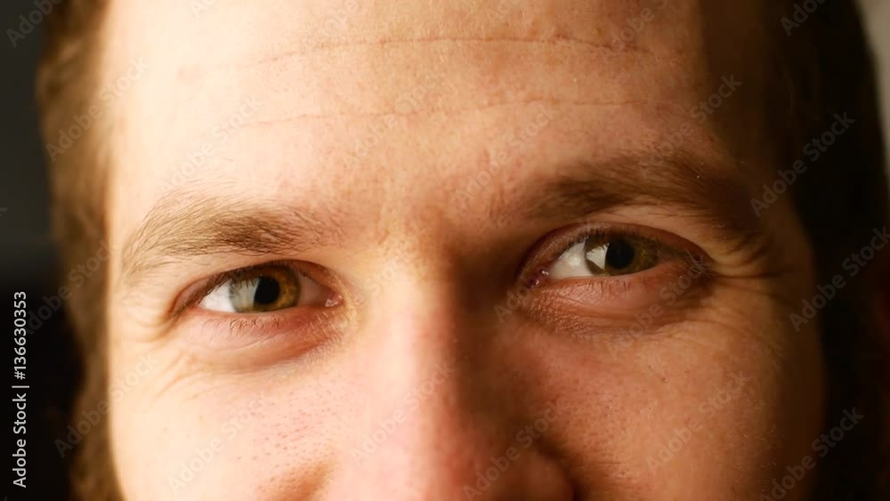 Close the eyes of a young white man with curly hair plan. The man turns his head and smiles visible facial wrinkles from smiling Close the eyes of a young white man with curly hair plan. The man turns his head and smiles visible facial wrinkles from smiling