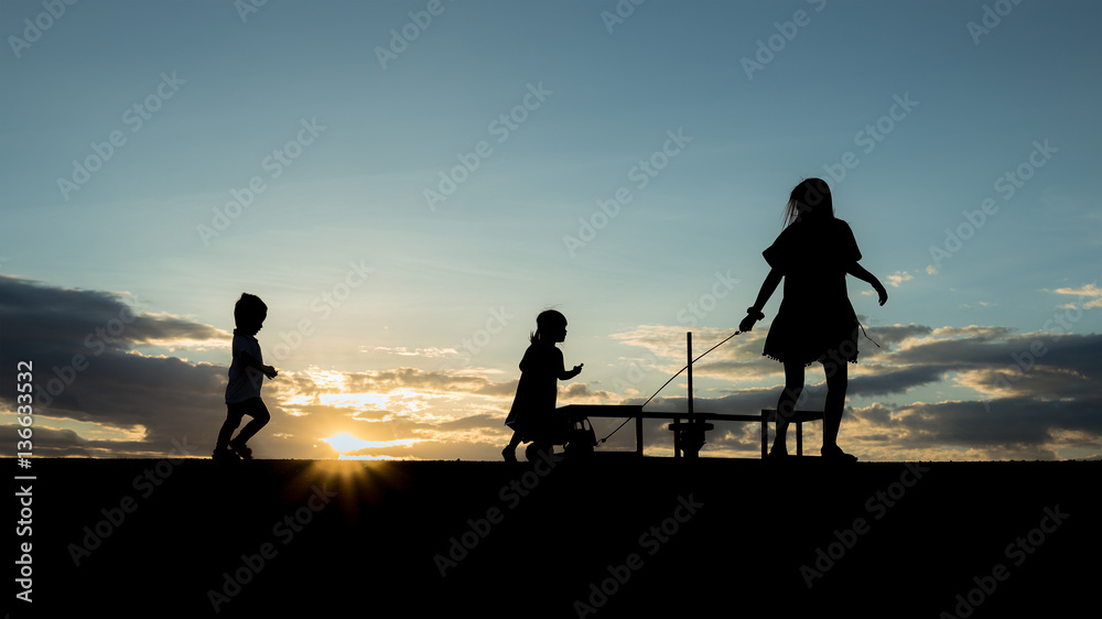 mother and children playing on the road at the sunset time. Conc
