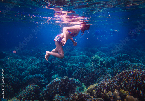 Underwater Photo of a Woman Diving , girl wearing bikini in action dive underwater ocean in thailand.