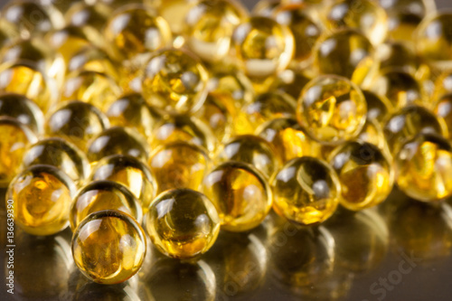a bunch of fish oil capsules on a dark background