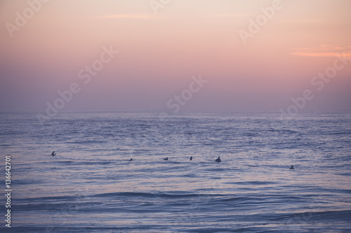 Surfers waiting for their wave at sunrise