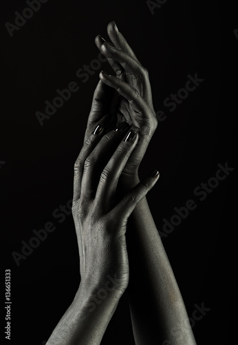 Dark-skinned hands over black background. Beautiful hands.