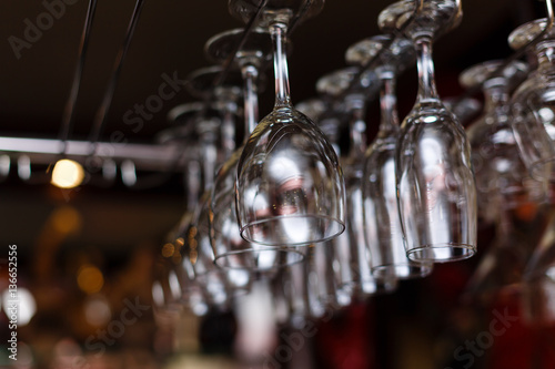different glasses hanging over the bar. Soft focus photo