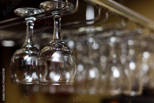 different glasses hanging over the bar. Soft focus photo
