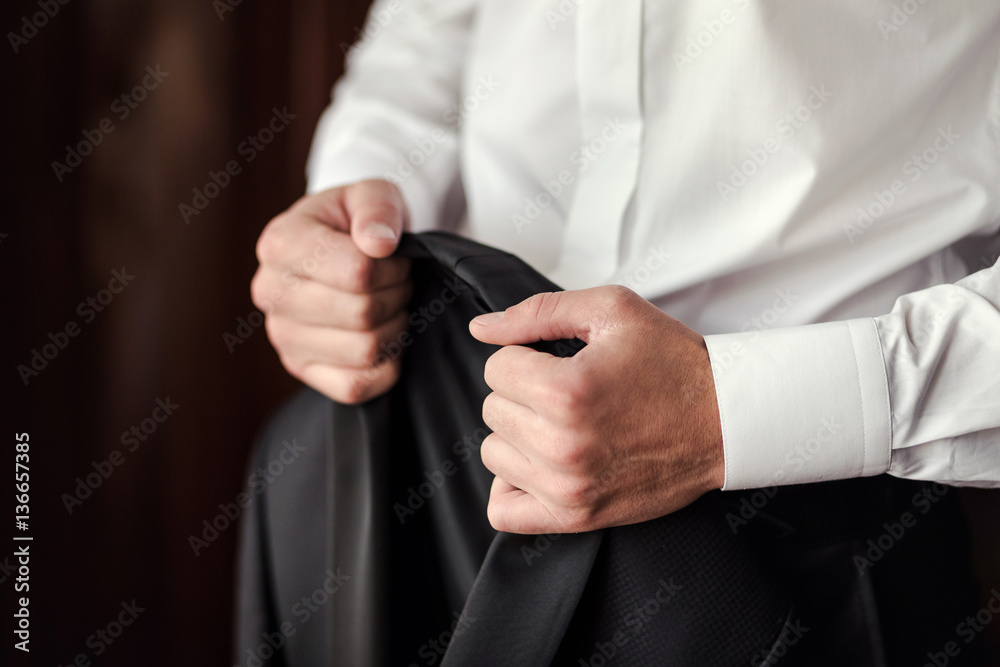 Fototapeta premium Businessman wears a jacket.Politician, man's style,male hands closeup, American, European businessman, business, fashion and clothing concept