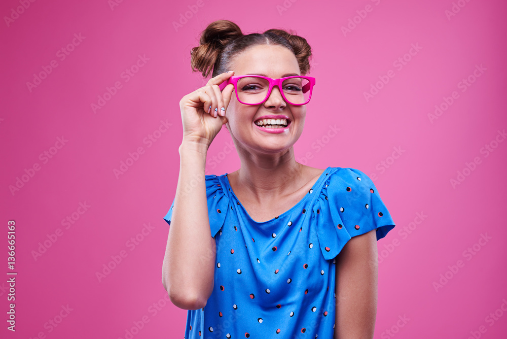 Broadly smiling teenage wearing pink glasses posing in studio Broadly smiling teenage wearing pink glasses posing in studio