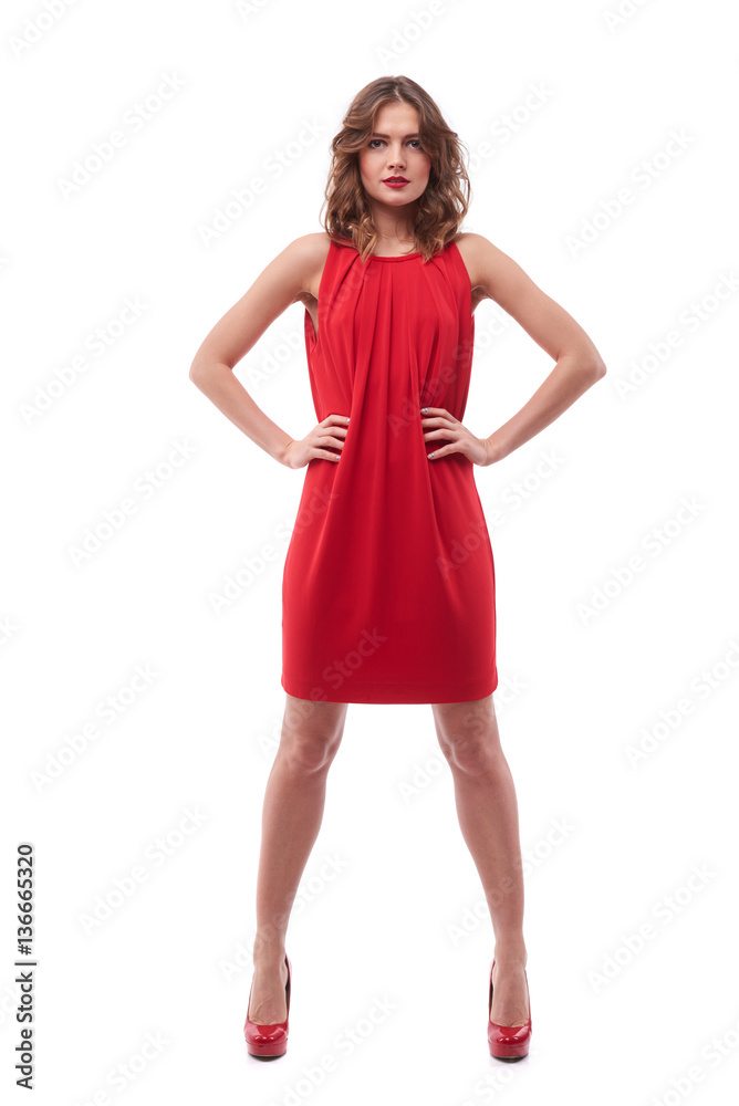 Confident young woman in red dress with hands on hips Confident young woman in red dress with hands on hips