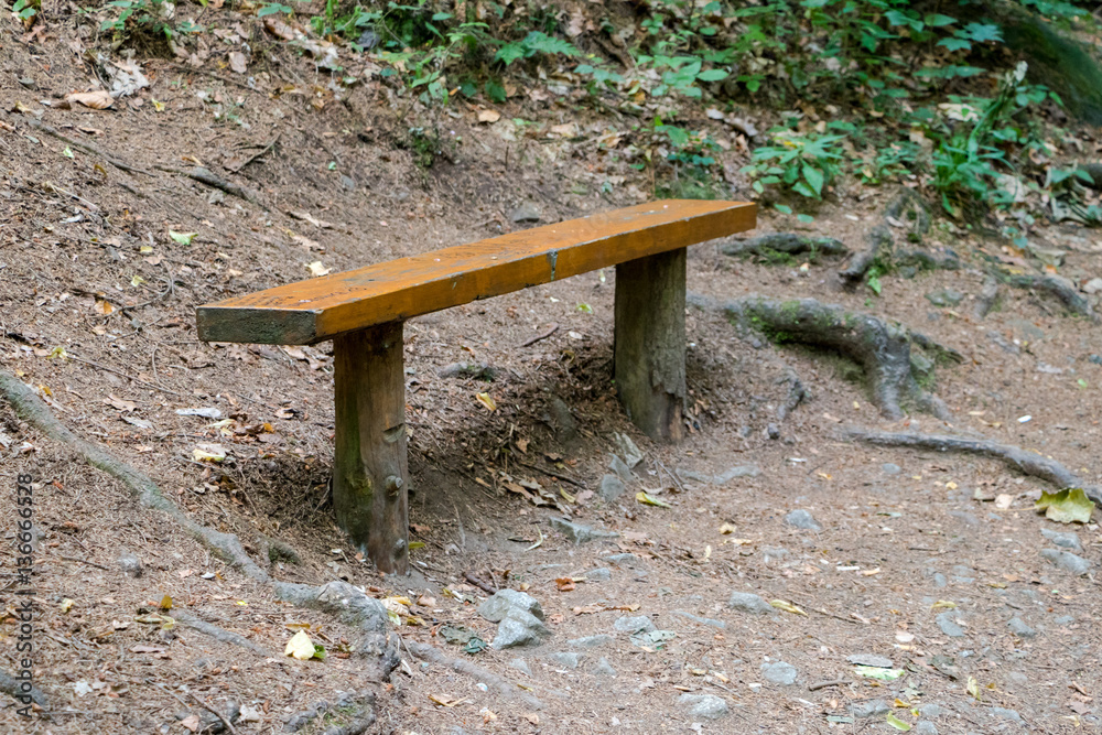 Wooden bench at hiking trail for rest and taking break Wooden bench at hiking trail for rest and taking break