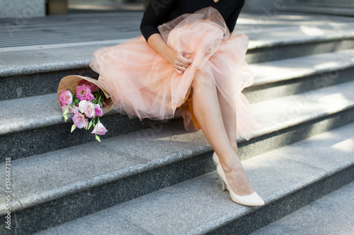 woman sitting on the stairs with flowers tutu skirt legs heel su