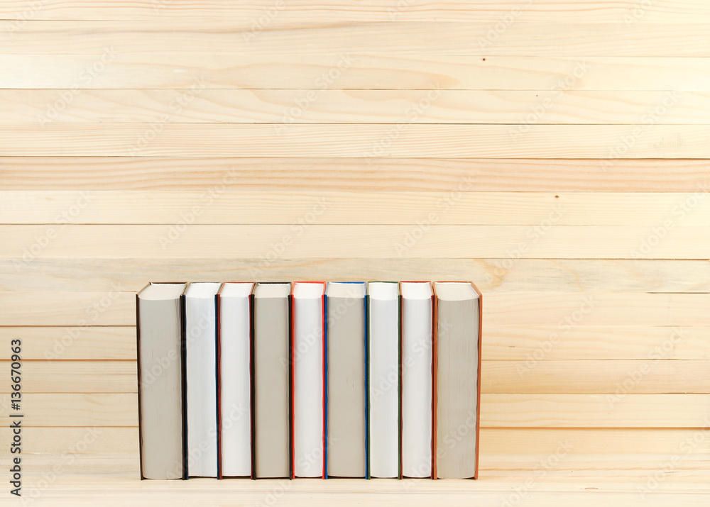 Naklejka premium Stack of hardback books on wooden table. Back to school. Copy space