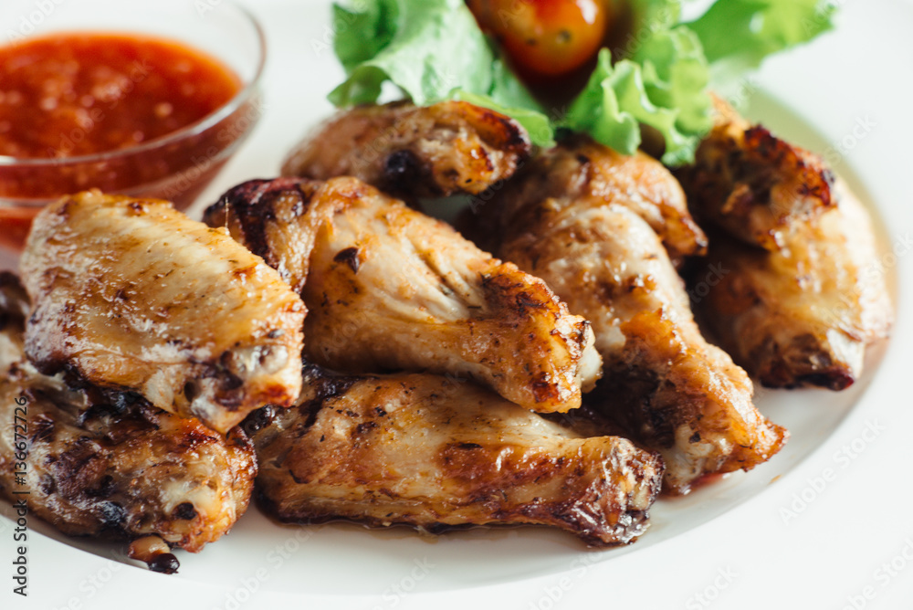 Chicken wings with sauce on plate on wooden table Chicken wings with sauce on plate on wooden table