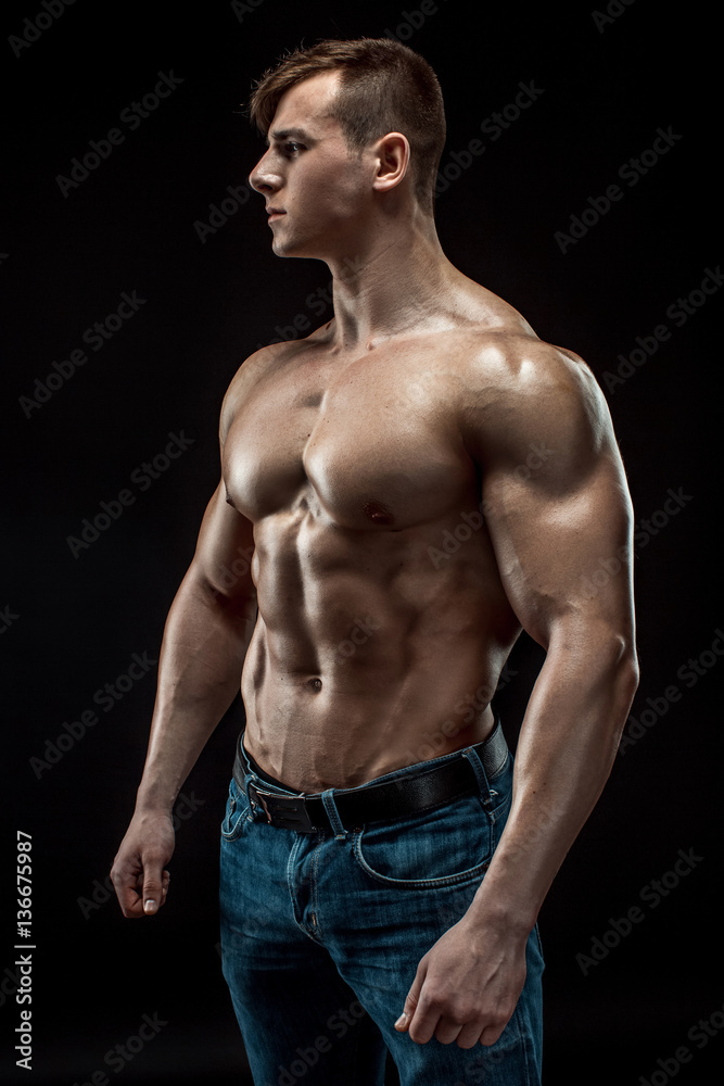 Fototapeta premium Young bodybuilder man on black background