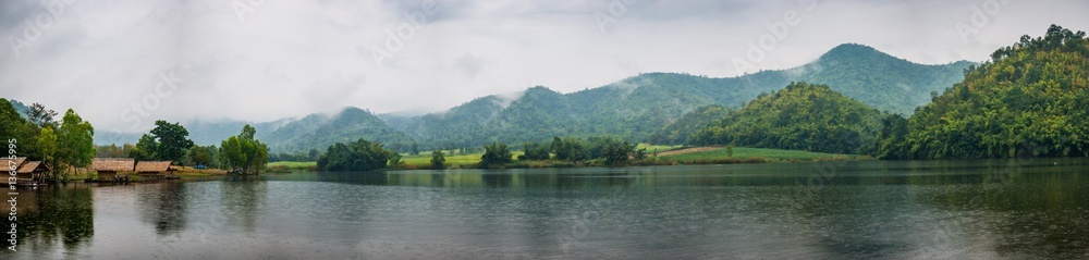 Beautiful tranquil lake and mountain covered with fog. Panorama