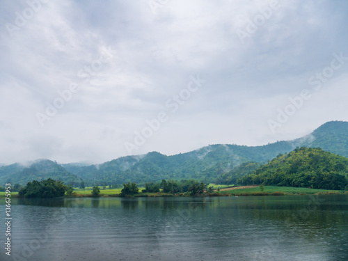 Beautiful tranquil lake and mountain covered with fog