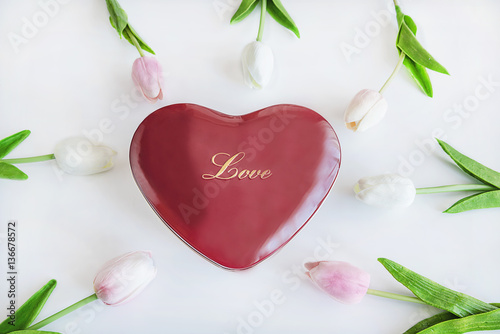greeting card/red gift box shaped heart and wihte and pink tulips on a white background top view
