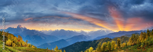Sunset over snow-capped mountain peaks. The view from the mounta