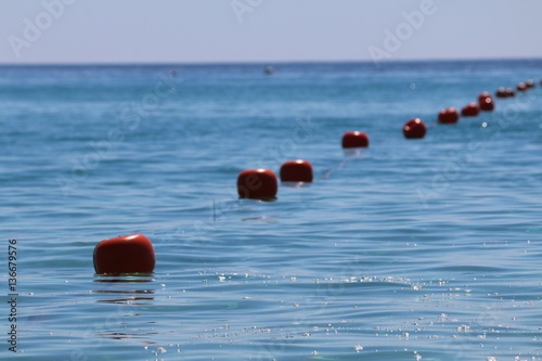 fila di boe rosse in mezzo al mare photo