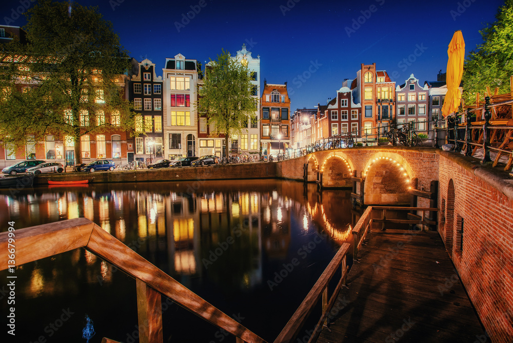 Canal in Amsterdam at night. Highlighting buildings and streets 