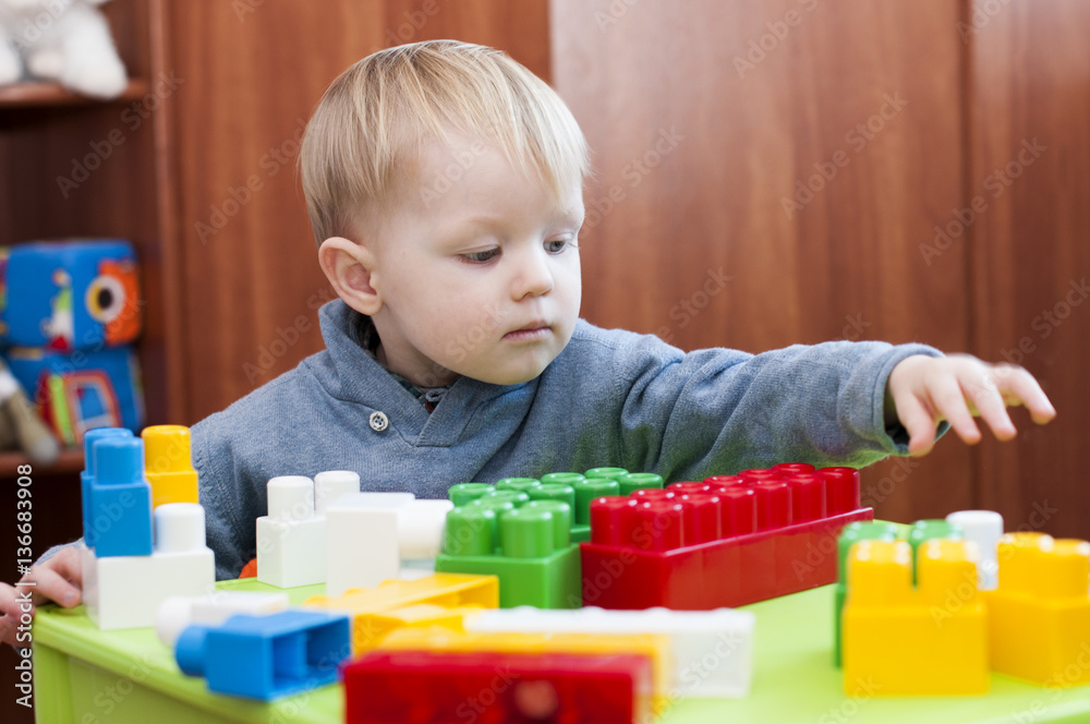 toddler reaching for a toy constuctor indoor toddler reaching for a toy constuctor indoor