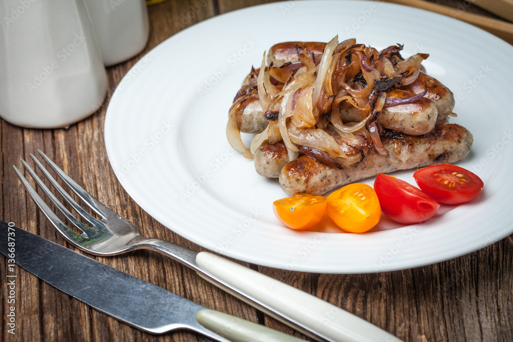 Fried Fried white sausages with onion on the plate.white sausage Fried Fried white sausages with onion on the plate.white sausage