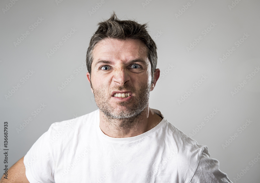 young attractive man with blue eyes looking angry and mad in rage emotion and upset young attractive man with blue eyes looking angry and mad in rage emotion and upset