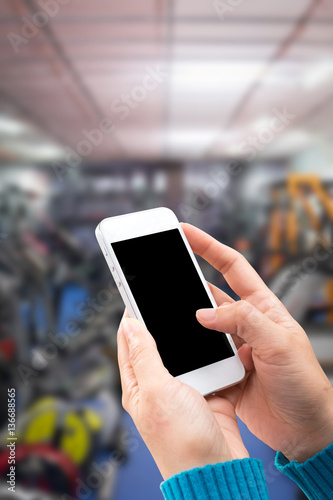 Woman hand holding and using mobile,cell phone,smart phone with isolated screen with blurred of department store the for background.