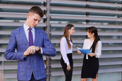 Modern young masculine guy businessman, student stands in foregr photo