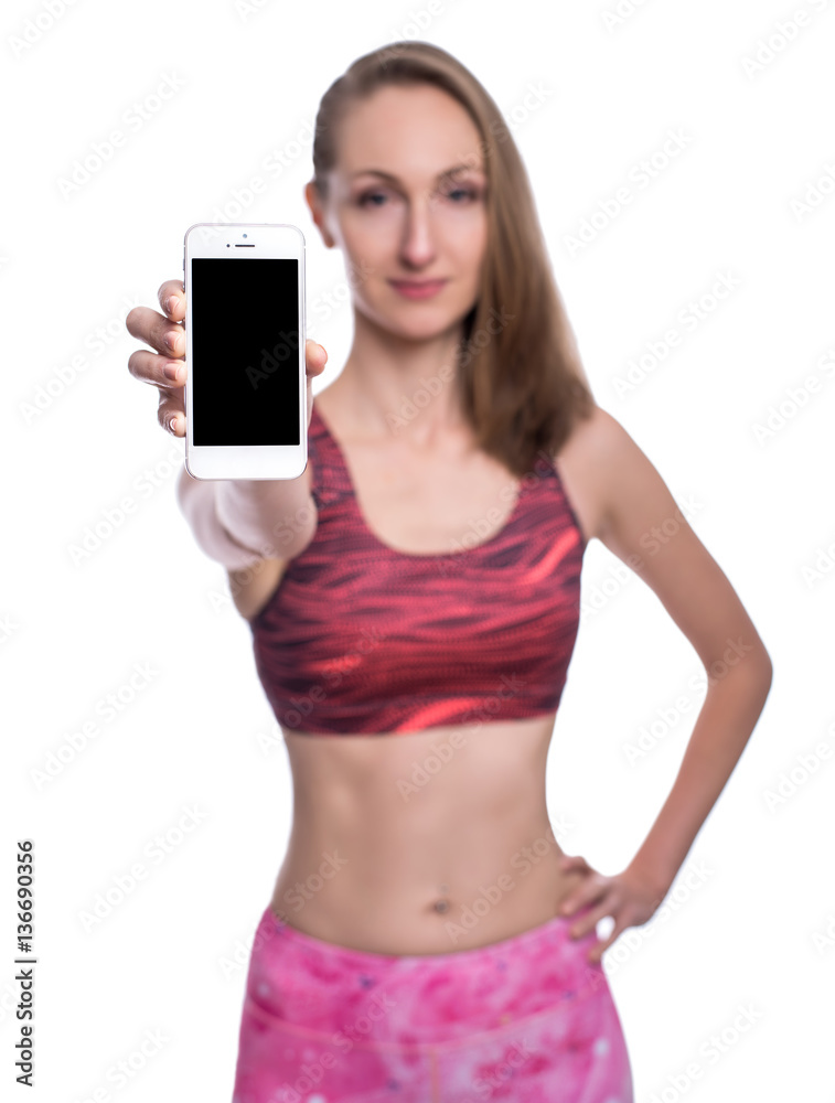 Happy smiling fitness girl showing blank smartphone screen in studio. Isolated over white background. Happy smiling fitness girl showing blank smartphone screen in studio. Isolated over white background.