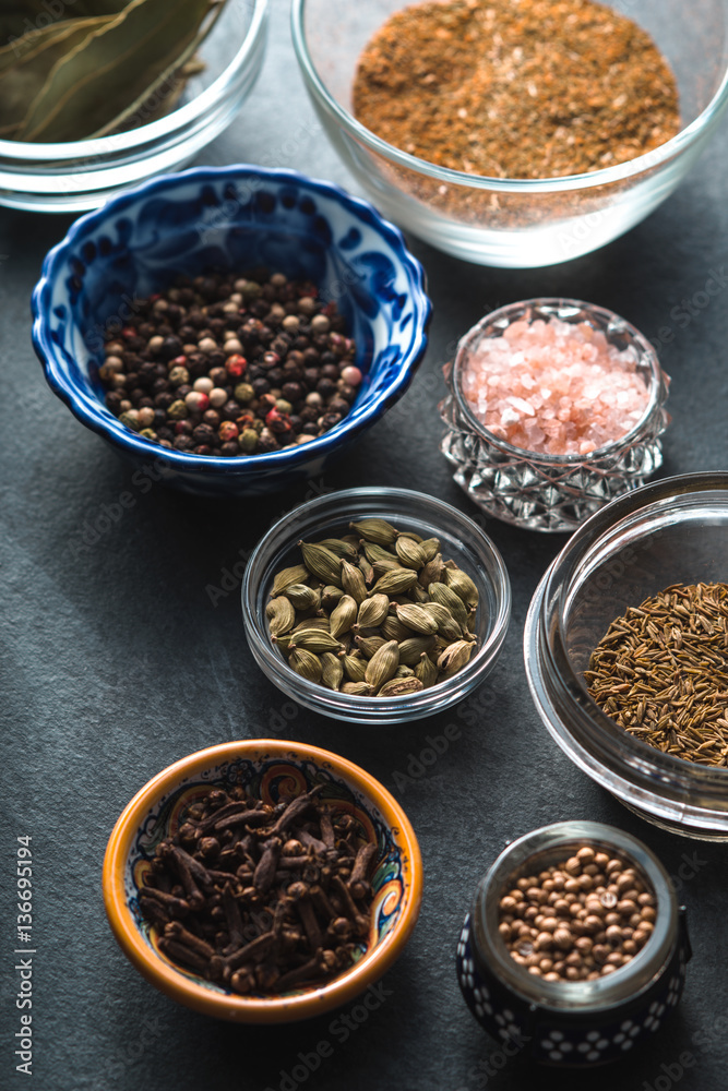 Various spices in a ceramic bowl on slate