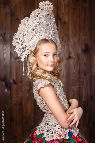 Russian girl in a folk russian dress on wooden background photo