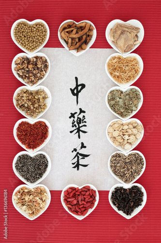 Chinese herbal tea selection in heart shaped bowls with calligraphy on rice paper. Translation reads as chinese herb tea. Used also in herbal medicine, photo