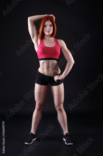 Young strong sexy woman showing her muscles.