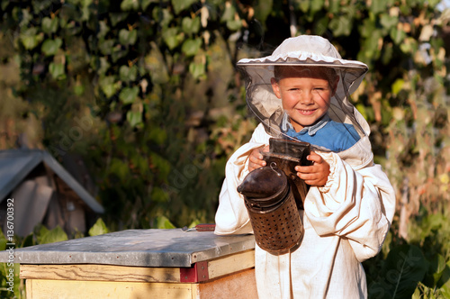 Beekeeper a young boy who works in the apiary. Beekeeping.