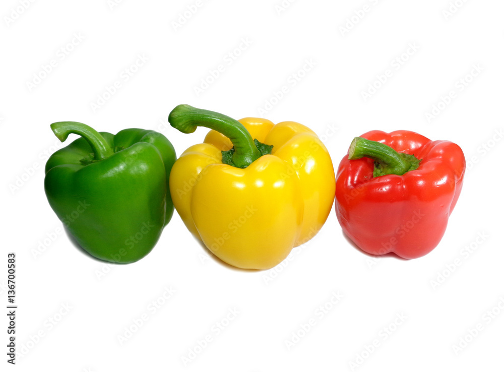 Three ripe vibrant color bell peppers, green, yellow and red with green stem isolated on white background
