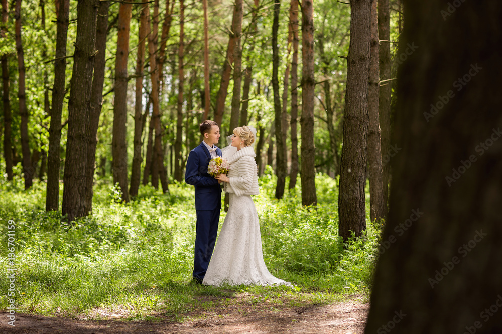 Bride and groom in forest at wedding day