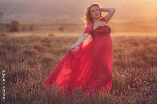 Beautiful provence pregnant woman relaxing in lavender field watching on sunset holding basket with lavanda flowers. Series. alluring girl with purple lavender. blond lady in blossom field