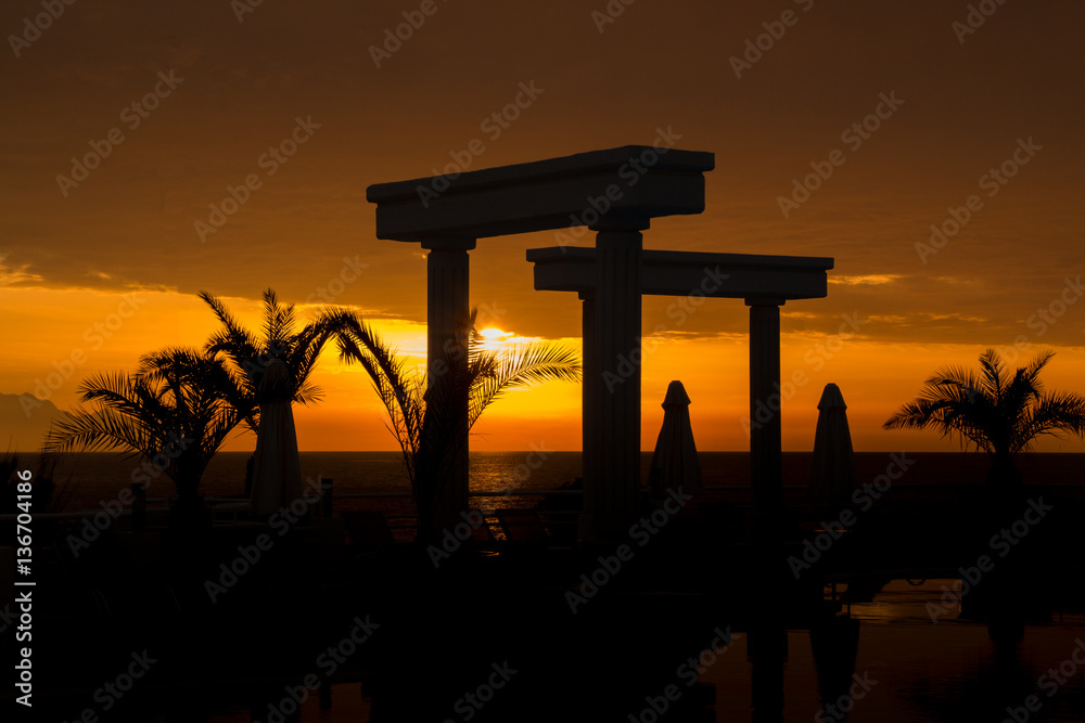 Sonnenuntergang am Pool mit Palmen und Säulen