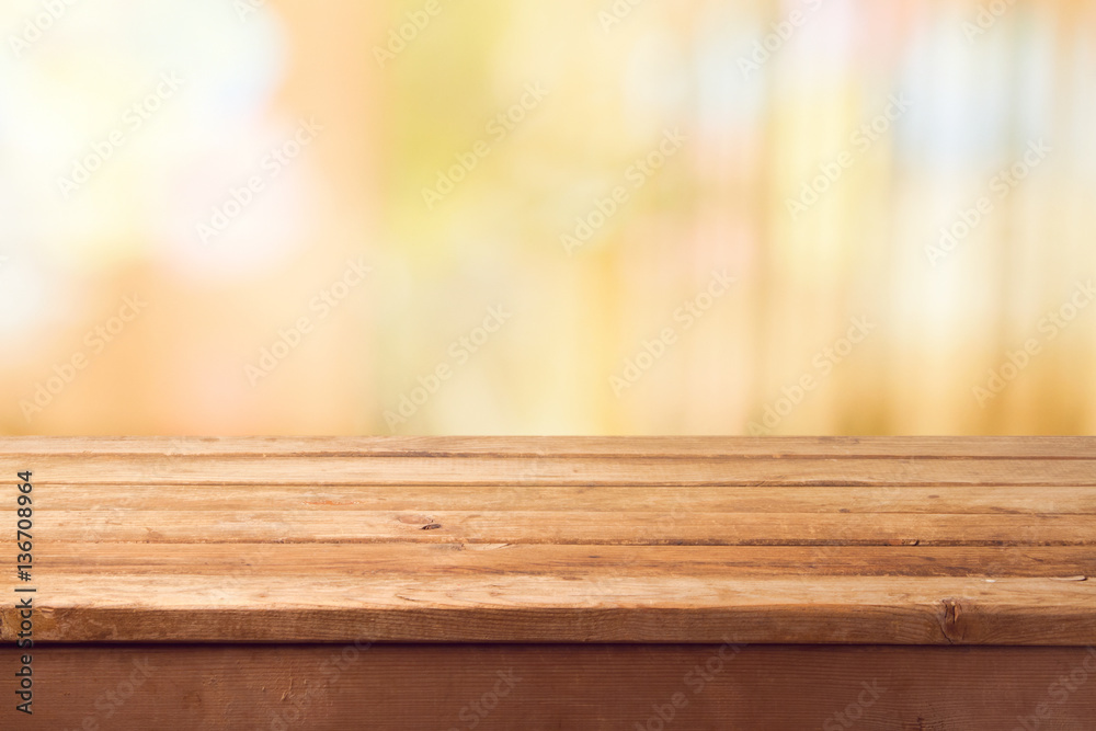 Empty wooden deck table over blurred warm bokeh background for product montage display Empty wooden deck table over blurred warm bokeh background for product montage display