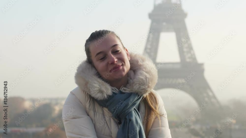 Young lady takes selfie in front of Eiffel tower in Paris Paris, France