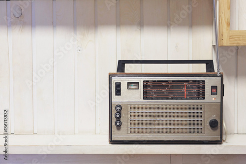 Retro old radio front white wooden background. Vintage style photo.