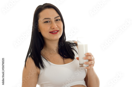 pretty brunette pregnant woman posing with glass of milk in hands isolated on white background