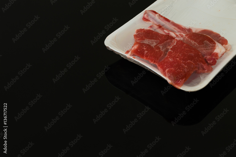 Packed pieces of red meat on black background