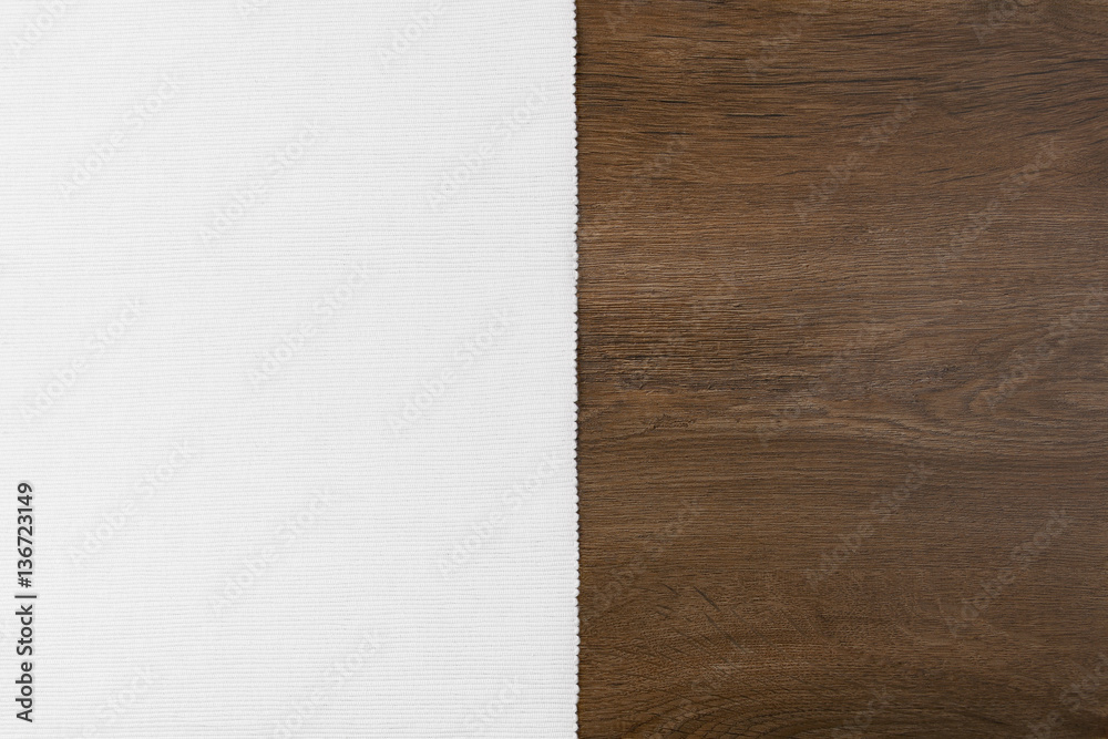 Naklejka premium White material from left side wooden table. Velvet and wood background with empty place.
