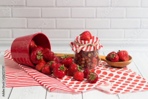 Delicious strawberry in jar and red pot
